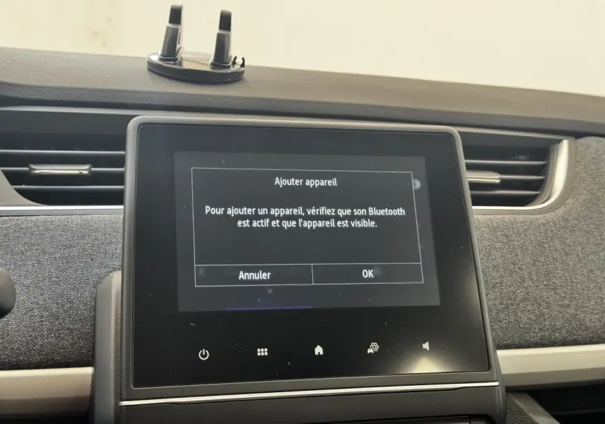 Écran tactile central de la Renault ZOE Iconic R135 blanc, vue intérieure frontale du tableau de bord.