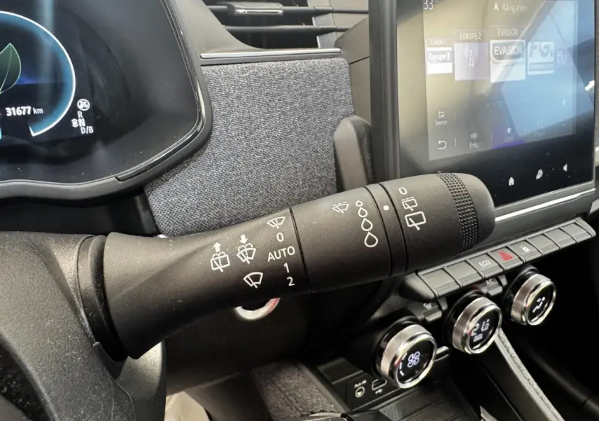 Gros plan sur la commande des essuie-glaces à gauche du volant dans l’habitacle de la Renault ZOE blanche Iconic R135 2022.
