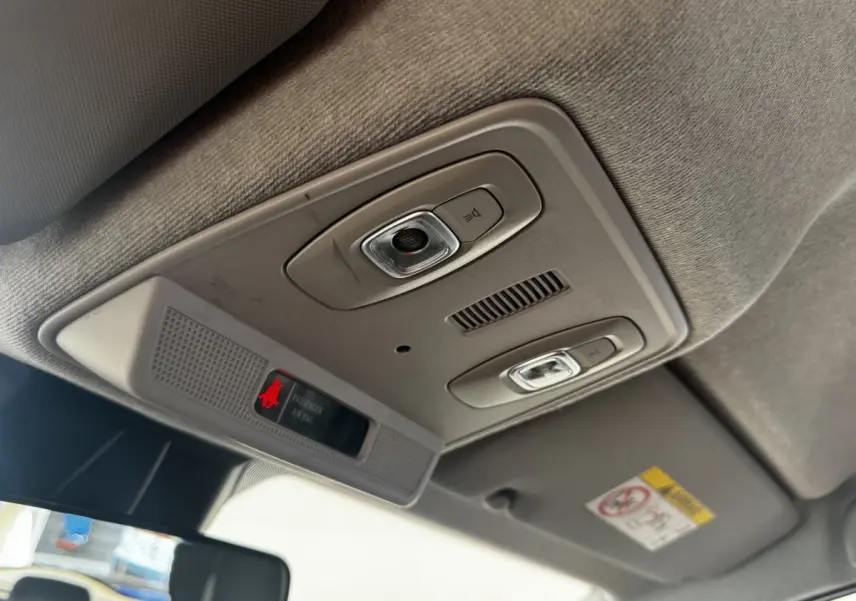 Vue intérieure du plafonnier gris clair de la Renault ZOE Iconic R135 avec éclairages et indicateur airbag passager.