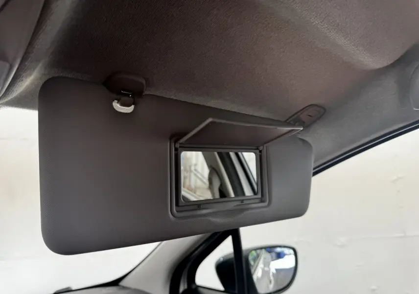 Détail intérieur du pare-soleil côté conducteur avec miroir rabattable dans une Renault ZOE blanche 2022.