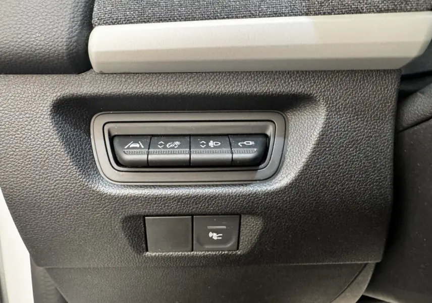 Gros plan sur les boutons de commande noirs intégrés dans la console intérieure noire et grise de la Renault ZOE blanche Iconic R135.