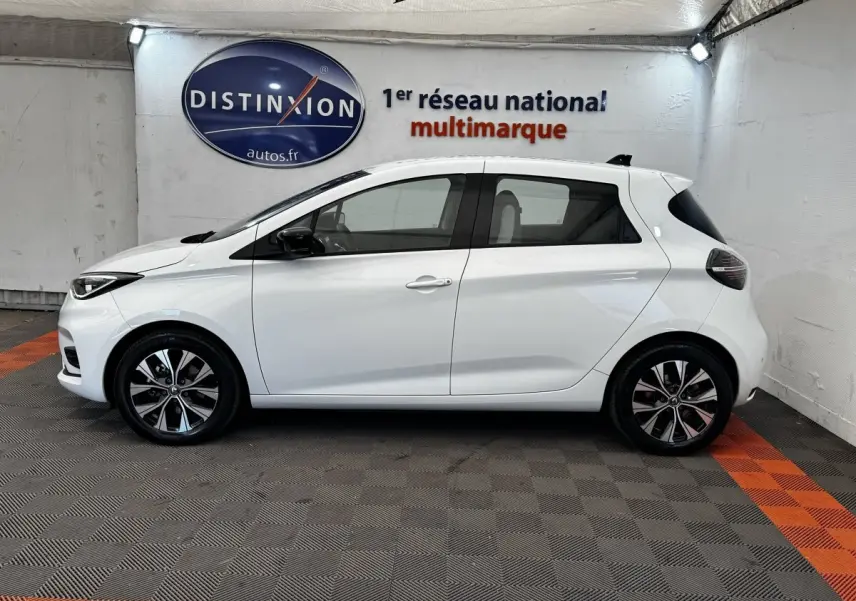 Profil droit de la Renault ZOE Iconic R135 blanche 2022, avec jantes alliage et vitres teintées.