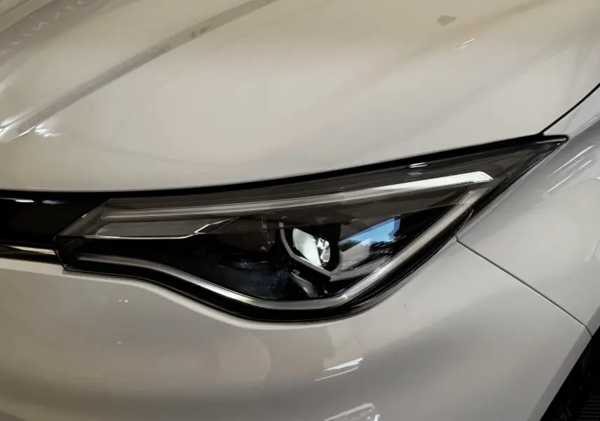 Gros plan sur le phare avant droit blanc d'une Renault ZOE Iconic R135 électrique de 2022.