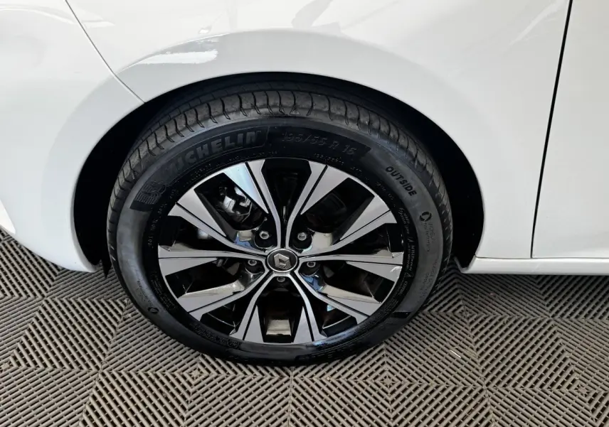 Gros plan sur la roue arrière droite d'une Renault ZOE blanche, mettant en valeur la jante alliage bicolore et le pneu Michelin.