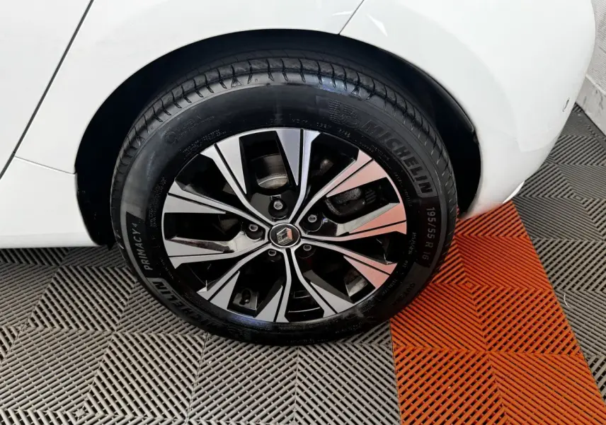 Gros plan sur la roue arrière droite blanche d'une Renault ZOE Iconic R135 avec jante alliage bicolore et pneu Michelin.
