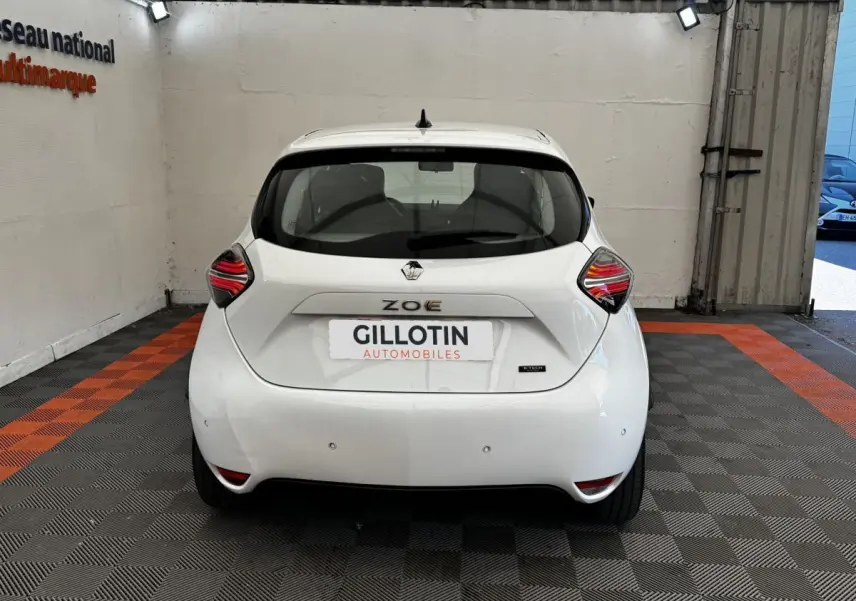 Vue arrière d'une Renault ZOE blanche Iconic R135 2022, avec feux arrière LED et logo distinctif au centre.