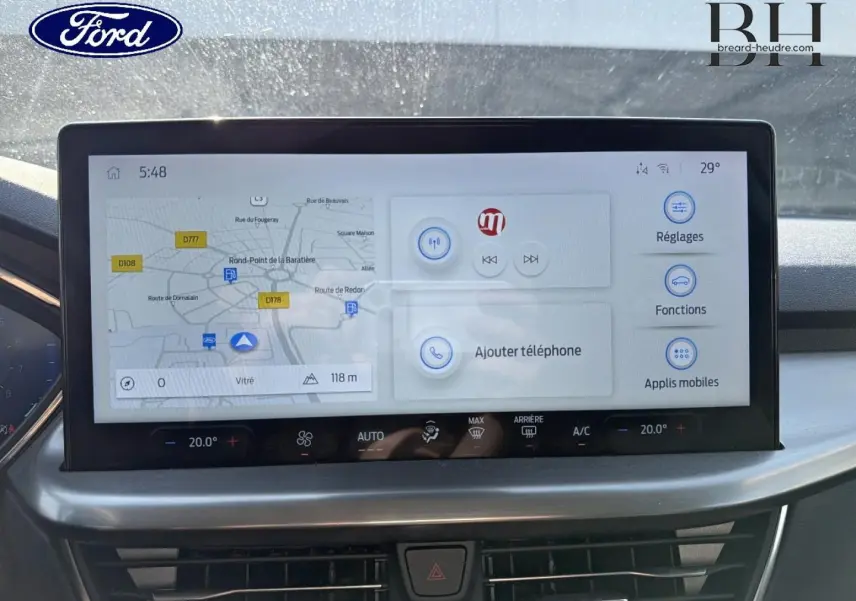 Écran tactile central de navigation et commandes climatisation dans Ford Focus gris Lunaire, vue de face intérieure.
