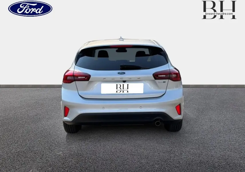 Vue arrière d'une Ford Focus 2023 gris lunaire métallisé avec feux LED et échappement chromé visible.