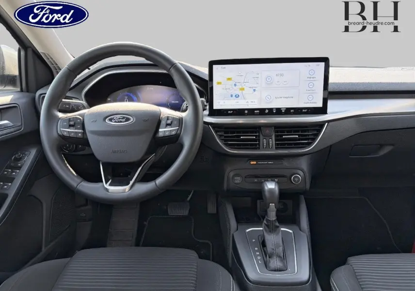 Vue frontale de l'intérieur de la Ford Focus 2023 avec tableau de bord noir et écran tactile central lumineux.