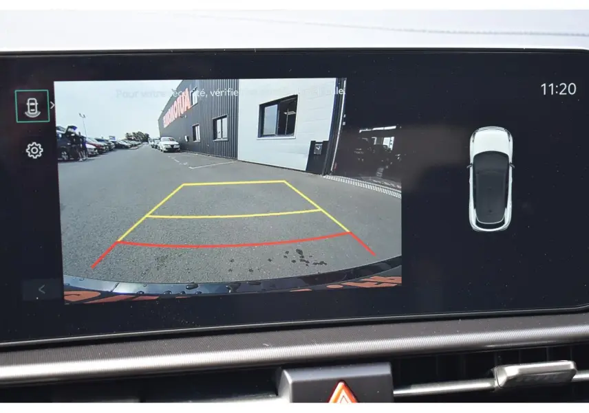Écran tactile affichant la caméra de recul du Kia Sportage noir, vue arrière avec lignes de guidage colorées.