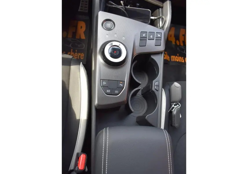 Vue plongeante sur la console centrale noire du Kia Sportage 2026 hybride avec commandes de sièges chauffants et frein électrique.