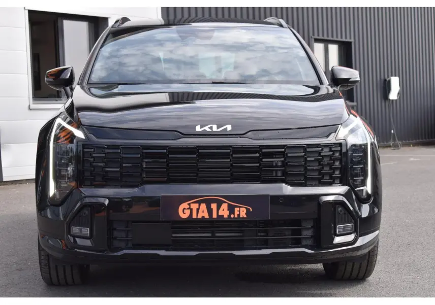 Vue frontale du KIA Sportage noir 2026 avec calandre noire et phares LED verticaux distinctifs.