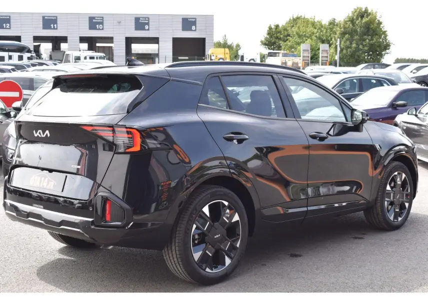 KIA Sportage hybride noir vue 3/4 arrière droit, jantes 19 pouces et feux arrière LED distinctifs.
