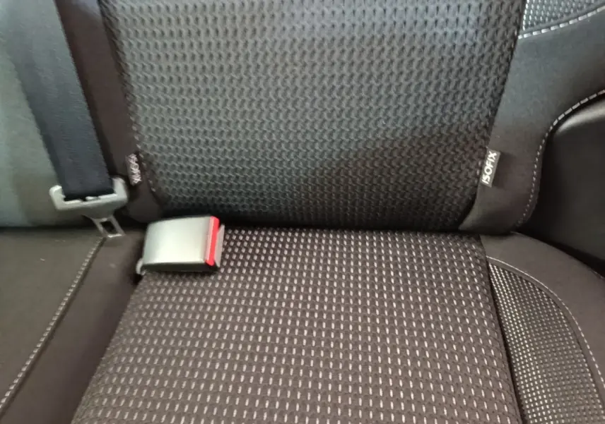 Gros plan sur la banquette arrière noire de la Peugeot 208 Puretech 82 Allure avec ceinture et étiquette ISOFIX visible.