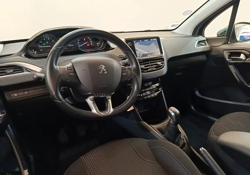 Vue intérieure avant de la Peugeot 208 Puretech 82 Allure 2019, tableau de bord noir avec écran tactile et volant cuir.