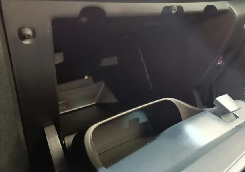 Intérieur de la Peugeot 208 Puretech 82 Allure 2019, vue rapprochée de la boîte à gants ouverte noire.