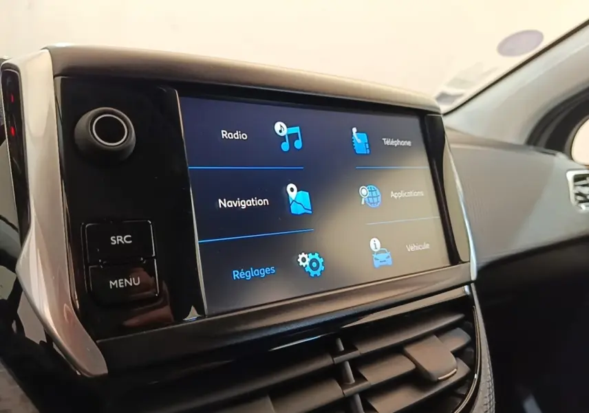 Gros plan sur l'écran tactile central du tableau de bord de la Peugeot 208 Puretech 82 Allure, intérieur noir.