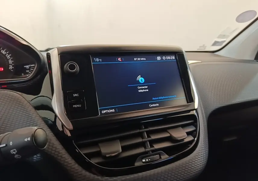 Vue rapprochée du tableau de bord noir et gris d’une Peugeot 208 Puretech 82 Allure avec écran tactile central allumé.
