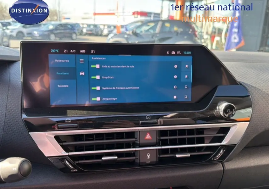 Vue rapprochée de l’écran tactile central et des commandes de la planche de bord d’une Citroën C4 X rouge Elixir Metal.