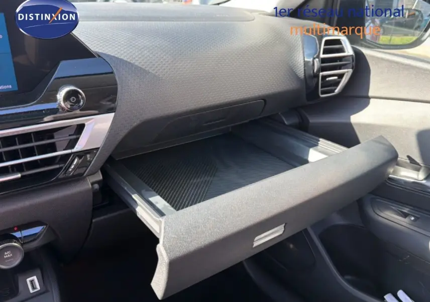Intérieur de la Citroën C4 X 2023, vue côté passager sur la boîte à gants ouverte et tableau de bord noir.