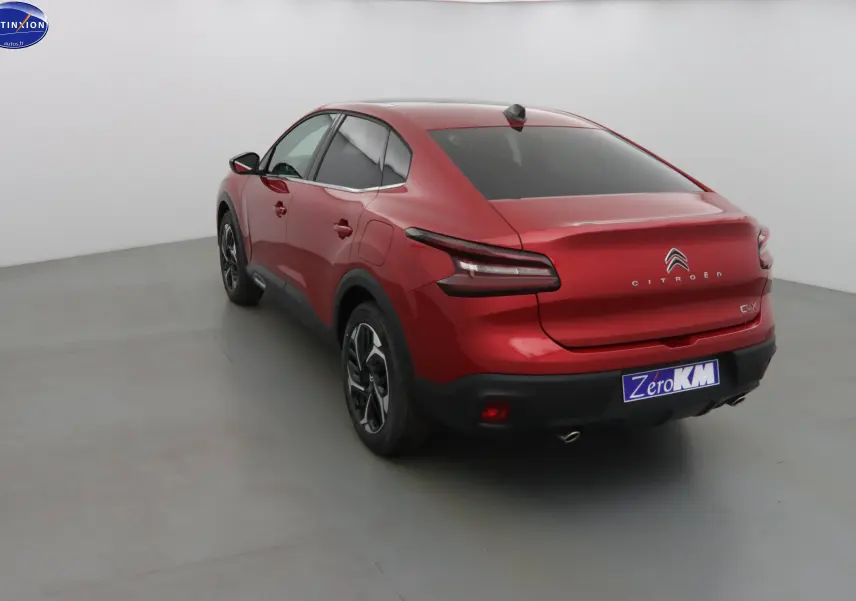 Vue 3/4 arrière droite d'une Citroën C4 X rouge Elixir Metal avec feux arrière LED et jantes bi-ton.