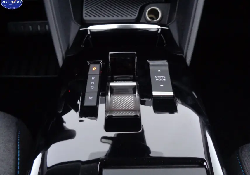 Gros plan sur la console centrale noire brillante de la Citroën C4 X 2023 avec sélecteur de boîte auto et bouton Drive Mode.