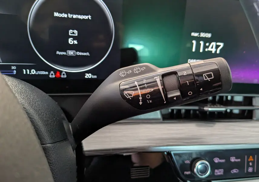 Gros plan sur la commande des essuie-glaces dans l'habitacle du Kia Sportage gris eclipse, tableau de bord numérique en arrière-plan.