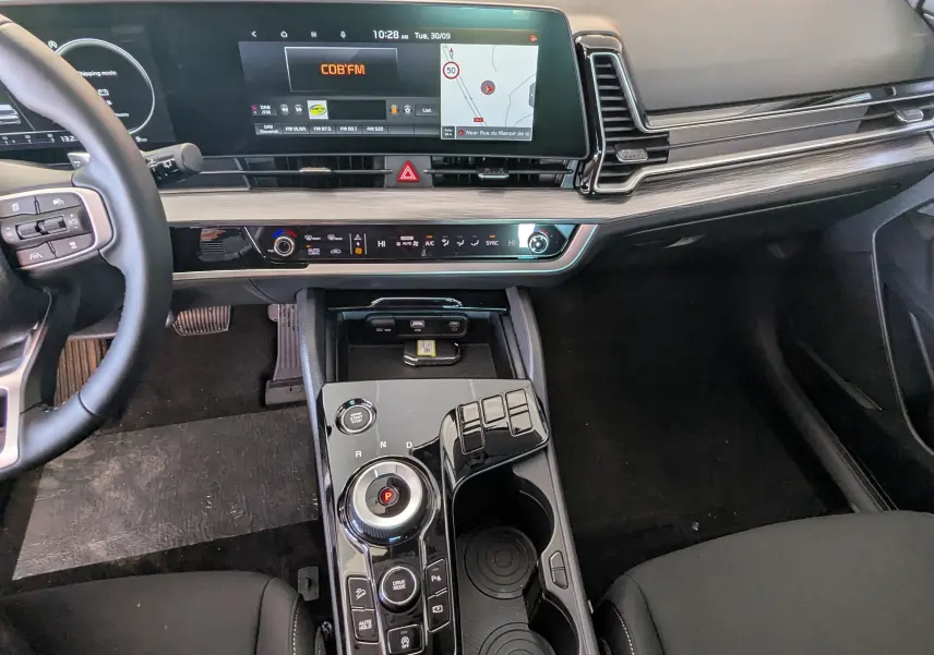 Intérieur du Kia Sportage MY25 gris eclipse, vue du tableau de bord et console centrale avec écran tactile et commandes modernes.