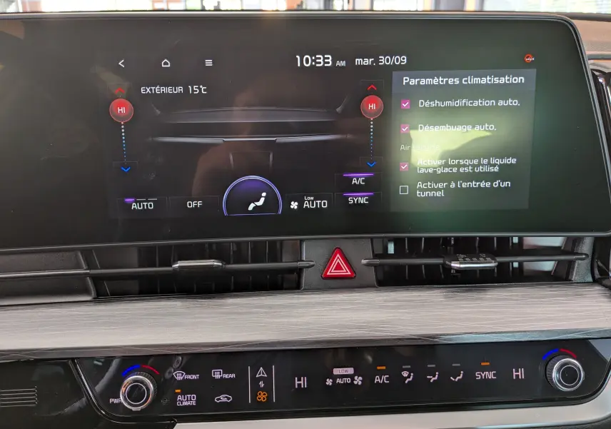 Écran tactile central et commandes de climatisation automatique du tableau de bord du Kia Sportage gris eclipse 2025.