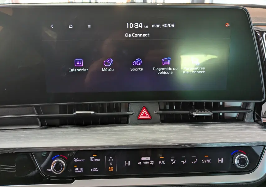 Vue rapprochée de l’écran tactile central et de la console de climatisation du Kia Sportage gris eclipse 2025.
