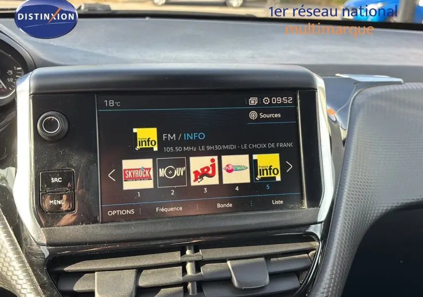Écran tactile central du tableau de bord d'une Peugeot 208 2019 affichant les stations radio FM, avec commandes autour.