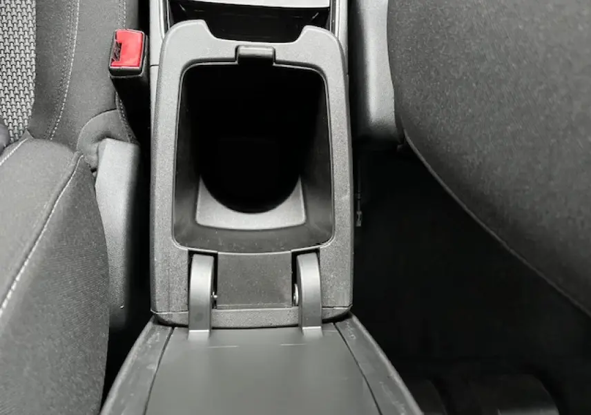 Vue plongeante sur le rangement central noir entre les sièges avant d'un Opel Grandland X gris clair de 2019.