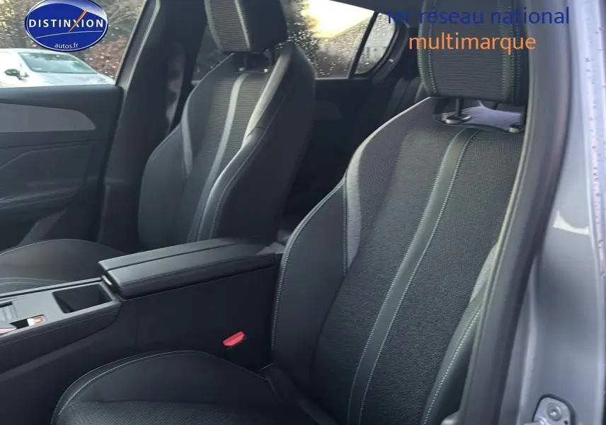 Vue intérieure côté droit sur les sièges avant gris foncé avec accoudoir central de la Peugeot 308 1.2 hybrid 145 allure 2025.