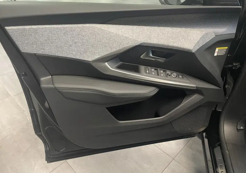 Vue intérieure de la porte avant gauche du Peugeot 3008 noir métallisé, avec garniture tissu et commandes électriques.