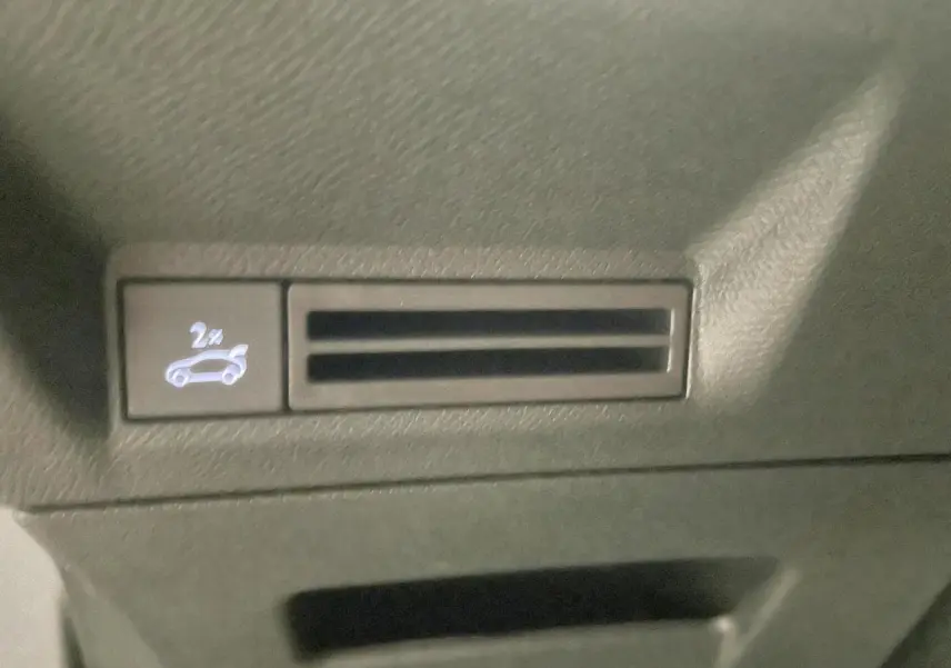 Détail du bouton d'ouverture du hayon électrique sur la console centrale du Peugeot 3008 noir métallisé 2025.