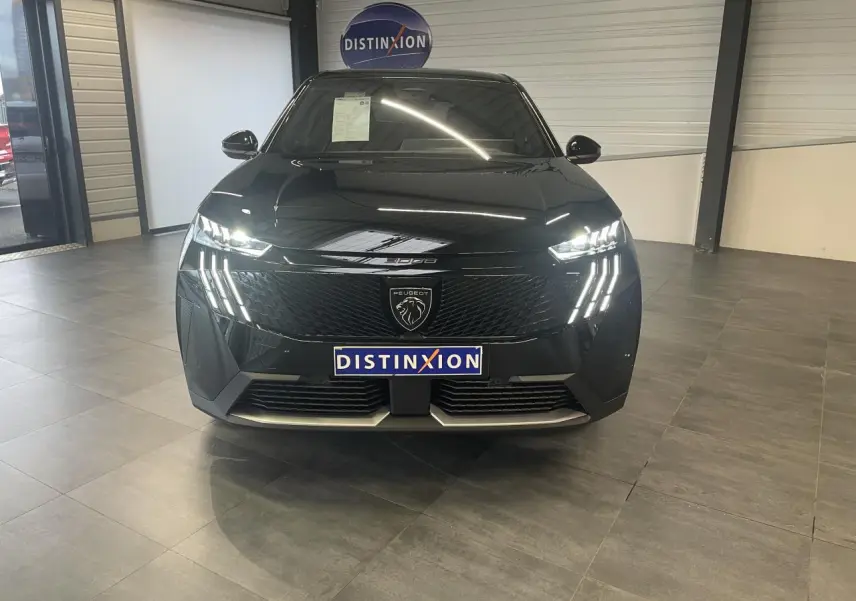 Vue frontale d’un Peugeot 3008 GT noir métallisé avec feux LED griffes et calandre noire laquée en showroom.