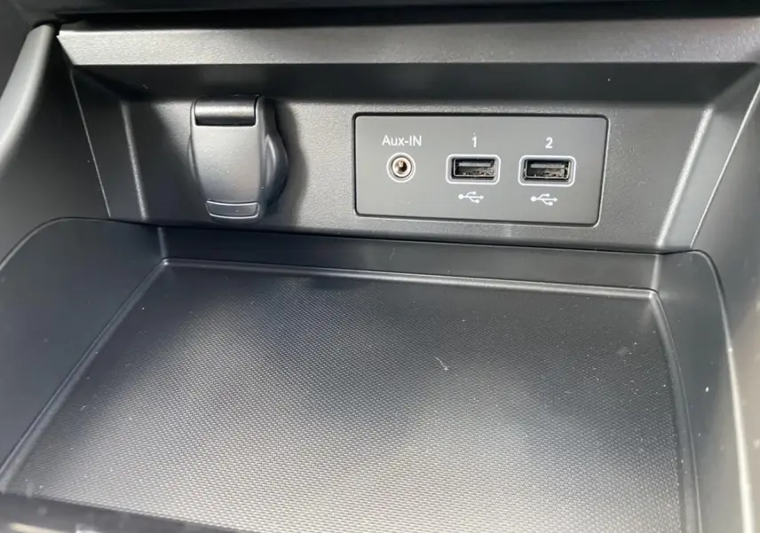Gros plan sur la console centrale noire du Renault Arkana 2022 avec ports USB et prise Aux-In visibles.