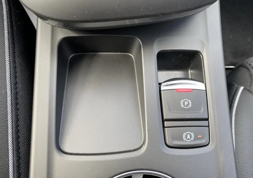 Gros plan sur la console centrale du Renault Arkana 2022, montrant le frein de parking électrique et le bouton Auto-Hold.
