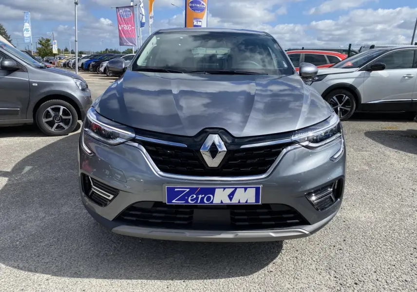 Vue de face d'un Renault Arkana gris foncé 2022 avec calandre noire et logo Renault bien visible.