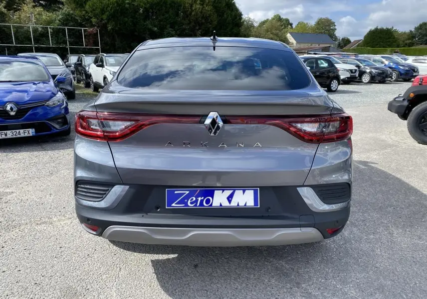 Vue arrière d'un Renault Arkana gris foncé 2022 avec feux LED et antenne aileron de requin sur un parking.