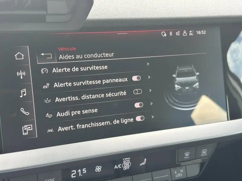 Écran tactile intérieur de l’Audi A3 Sportback 2024 affichant les aides à la conduite avec interface sombre et icônes blanches.