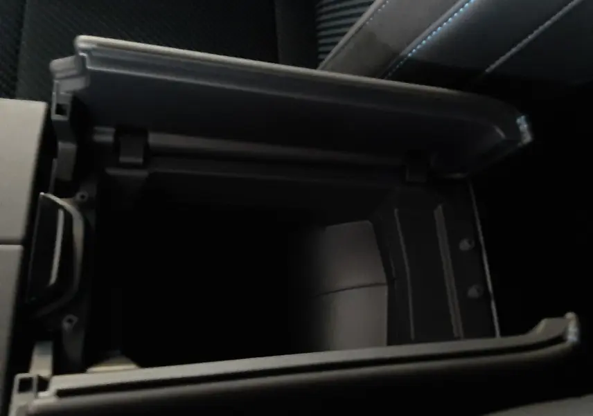Vue rapprochée de la console centrale ouverte avec rangement intérieur sur Renault Austral gris schiste satin.