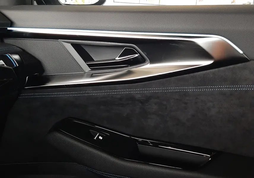 Détail de la porte côté gauche du Renault Austral E-Tech gris schiste satin, avec insertions noires et surpiqûres bleues.