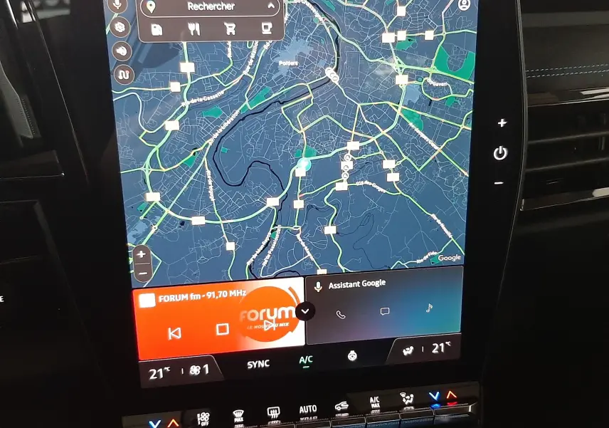 Écran central tactile du Renault Austral E-Tech hybride, affichant la navigation et les commandes climatiques, intérieur noir.