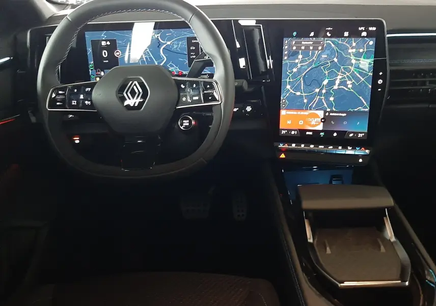 Vue intérieure du tableau de bord du Renault Austral E-Tech, avec volant multifonction et grand écran tactile central affichant la navigation.