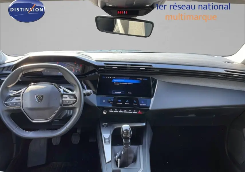 Vue intérieure avant du tableau de bord de la Peugeot 308 2024, volant cuir et écran tactile central noir.