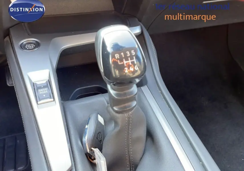 Gros plan sur la commande de boîte manuelle et la clé dans la console centrale d'une Peugeot 308 2024.