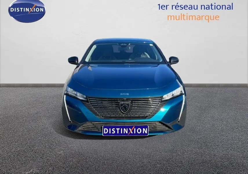 Vue frontale d'une Peugeot 308 2024 bleu obsession métal avec calandre distinctive et phares LED fins.