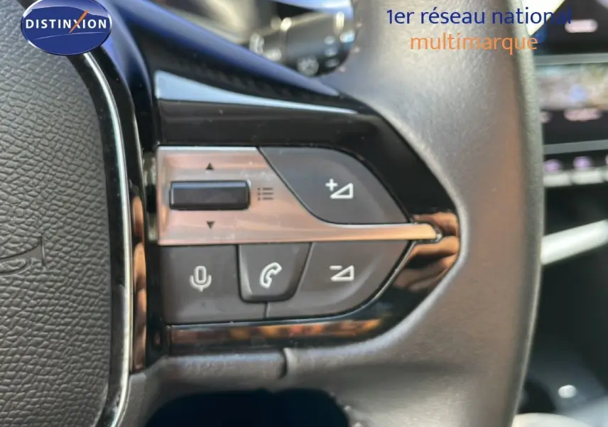Gros plan sur les commandes au volant en cuir noir de la Peugeot 308 1.2 PureTech 130ch Allure 2024 bleu obsession métal.
