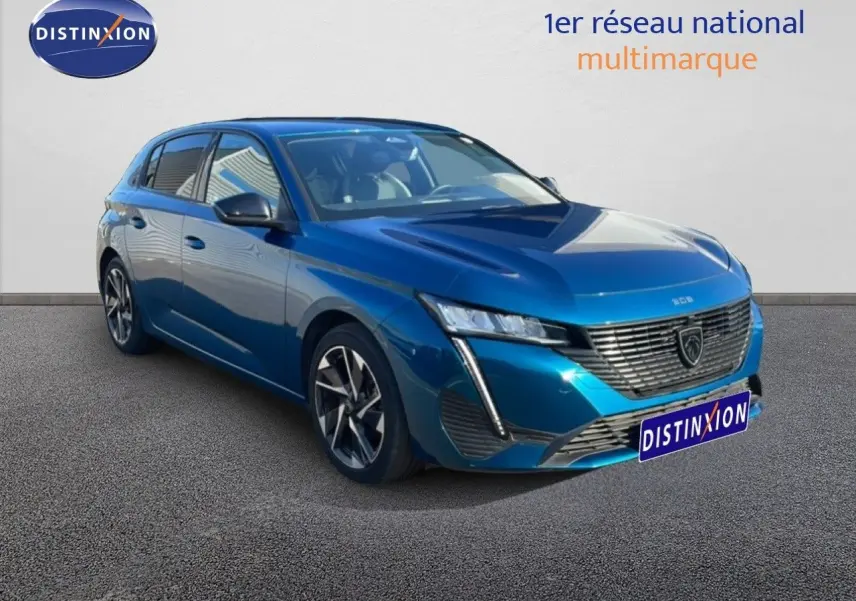 Peugeot 308 bleu obsession métal vue 3/4 avant droit, mettant en valeur sa calandre distinctive et ses jantes bicolores.